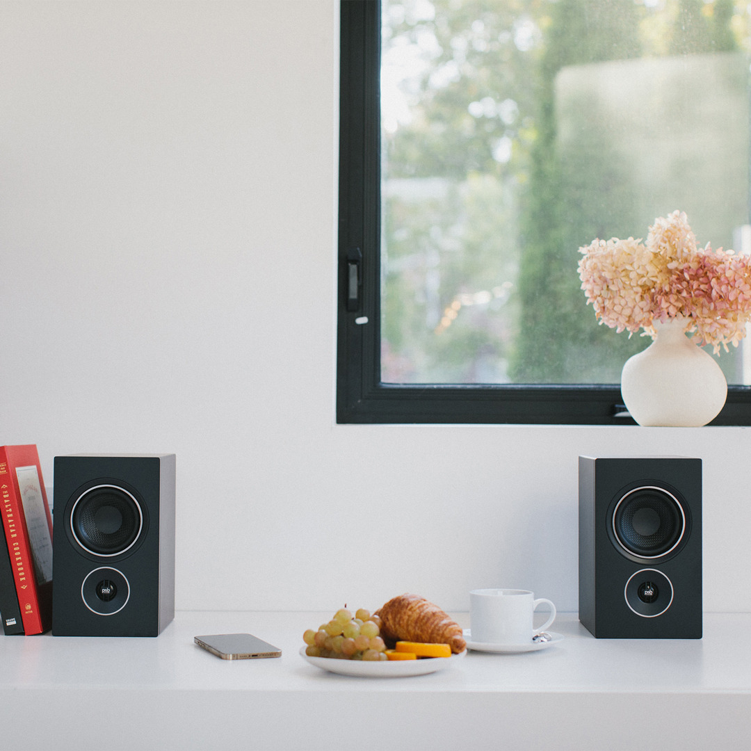 Black Alpha iQ speakers in a home environment.